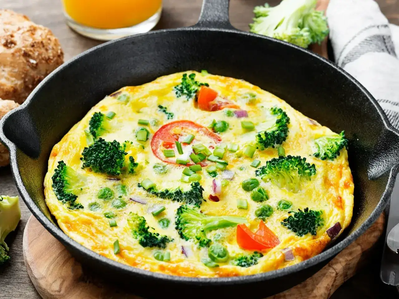 Szybka kolacja w 5 minut: puszysty omlet z brokułami, pomidorkami i szczypiorkiem na patelni.