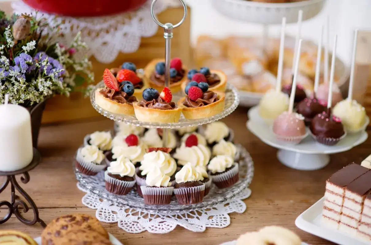 Słodkie przekąski na imprezę: babeczki, tartaletki z owocami, cake pops i ciasto czekoladowe.