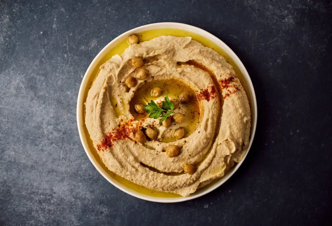 Kremowy hummus z ciecierzycą, oliwą i papryką. Idealny przepis na to, jak zrobić hummus w domu.