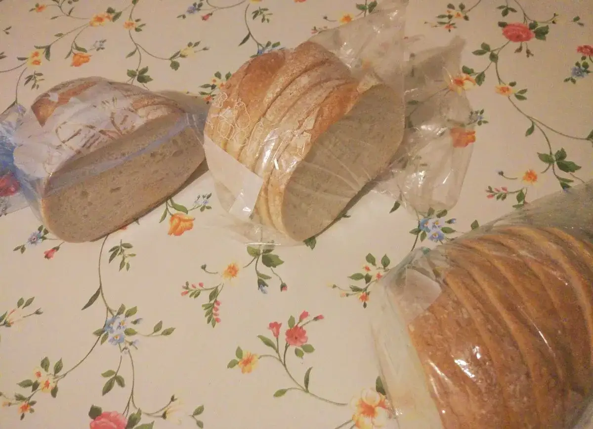 Chleb pokrojony w plastry, zapakowany w folię, gotowy do zamrożenia. To prosty sposób, jak mrozić chleb, by dłużej zachował świeżość.