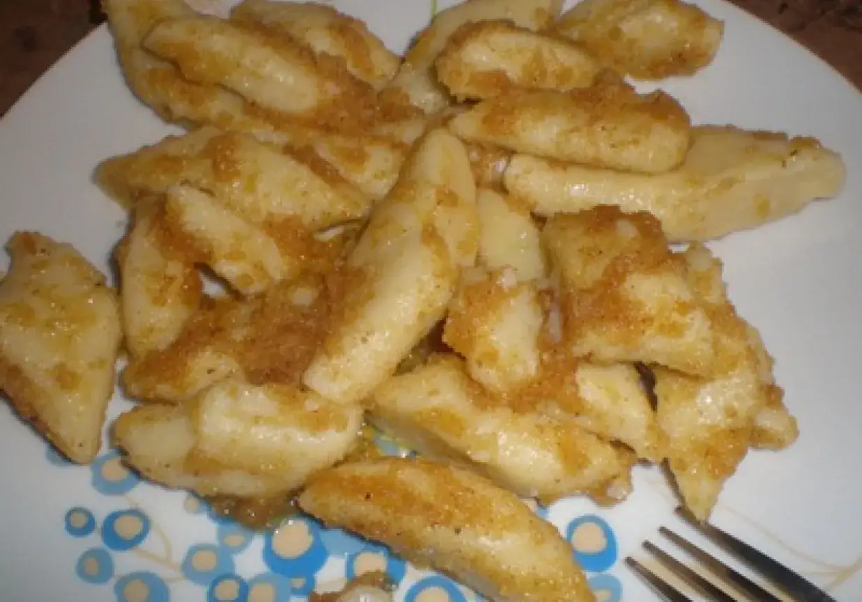 Pyszne leniwe pierogi posypane bułką tartą z masłem, gotowe do jedzenia.