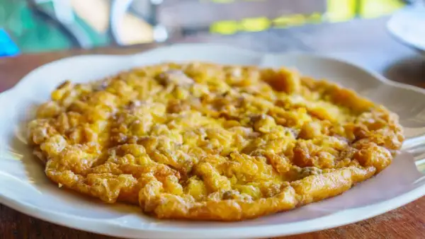 Złocisty omlet na białym talerzu, idealny omlet na kolację.