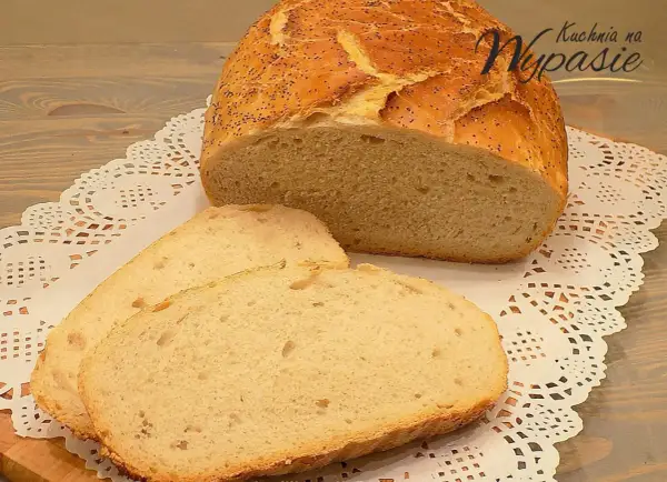 Pyszny, pachnący chleb domowy z makiem, pokrojony na kromki, leży na ozdobnej serwetce.