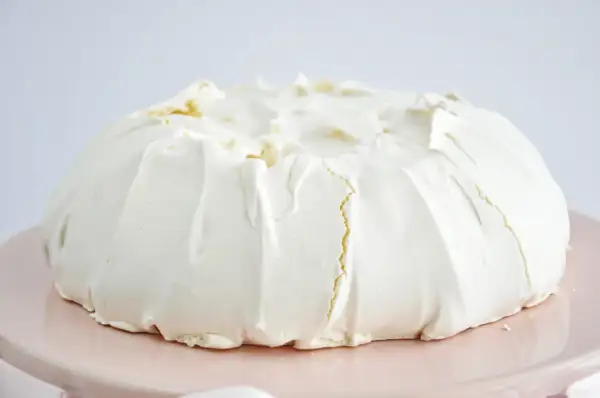 Puszysta beza pavlova z kremem, gotowa do dekoracji owocami.