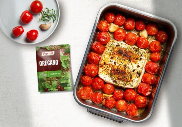 Pieczona feta z pomidorami i czosnkiem, doprawiona oregano. Pyszne danie gotowe do podania.