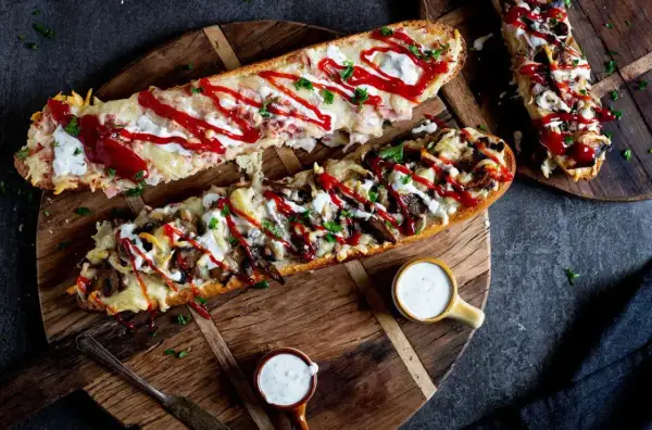 Pyszny domowy fast food: zapiekane bagietki z serem, pieczarkami i sosem. Idealne na szybki posiłek.
