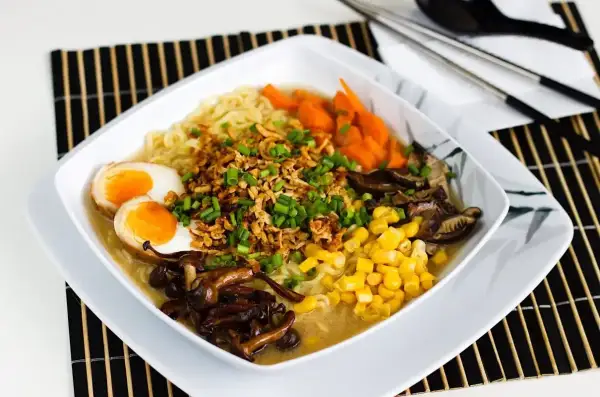 Pyszny tantanmen ramen z jajkiem, kukurydzą, marchewką i grzybami.