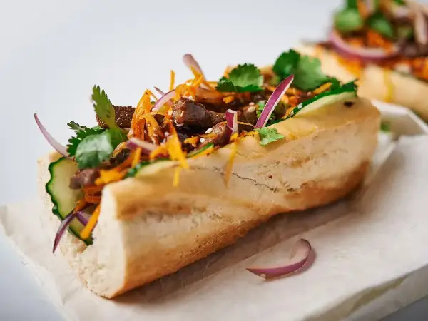 Pyszny banh mi przepis: bagietka z wołowiną, ogórkiem, marchewką, kolendrą i czerwoną cebulą.
