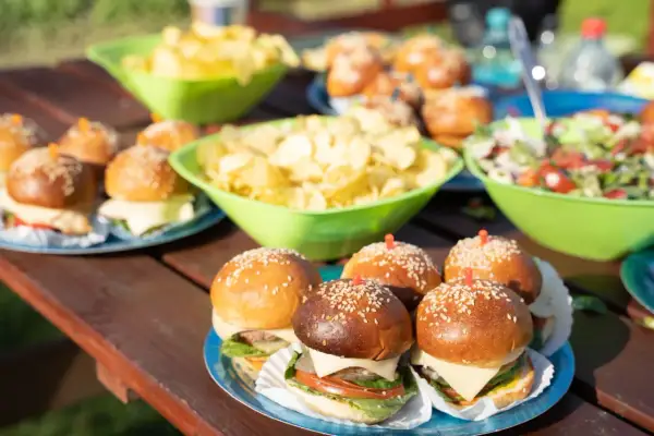 Mini burgery i chipsy na stole – idealne przekąski na szybko dla gości.