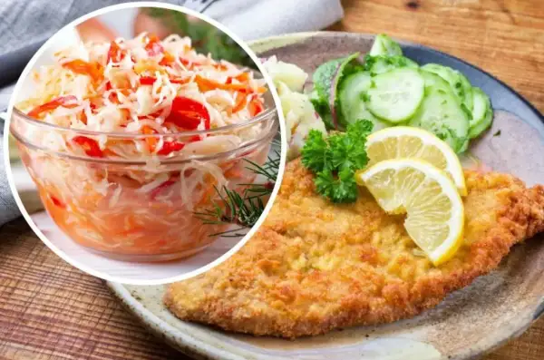 Idealna surówka do gołąbków to ta z kapusty z marchewką i papryką. Na talerzu kotlet schabowy z ziemniakami i ogórkiem.