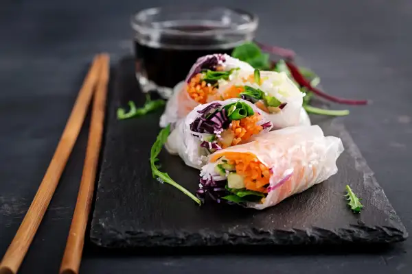 Świeże spring rolls z warzywami i ryżem, podane z sosem.