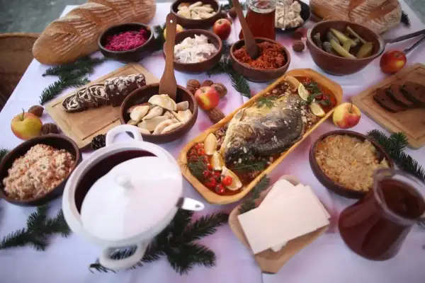 Wielkanocny stół pełen tradycyjnych potraw: ryba, pierogi, kapusta, chleb i surówki. Inspiracje na przepisy na wielkanoc.